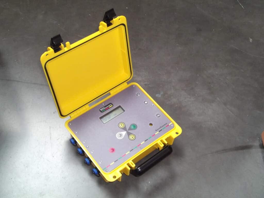 Valise de mesures jaune ouverte, écran et boutons de contrôle visibles.