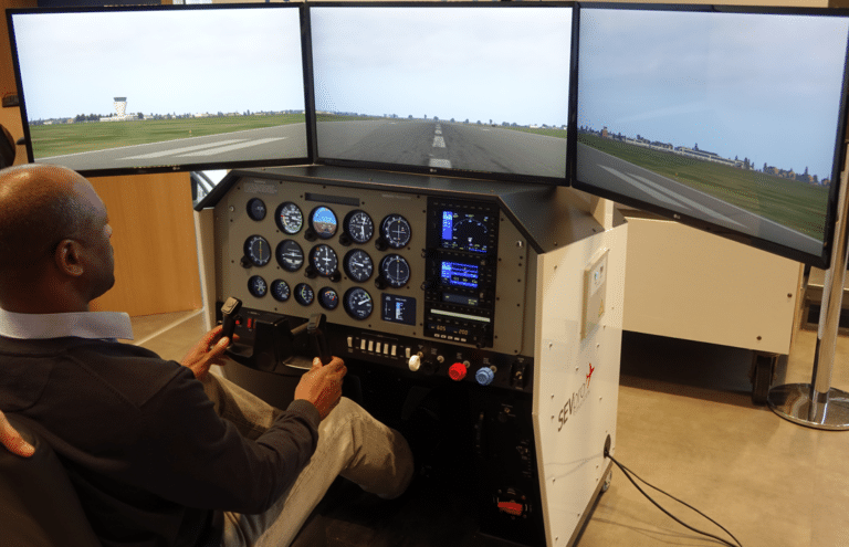 Simulateur de vol : Homme utilisant un simulateur de vol avec trois écrans affichant une piste d'atterrissage.