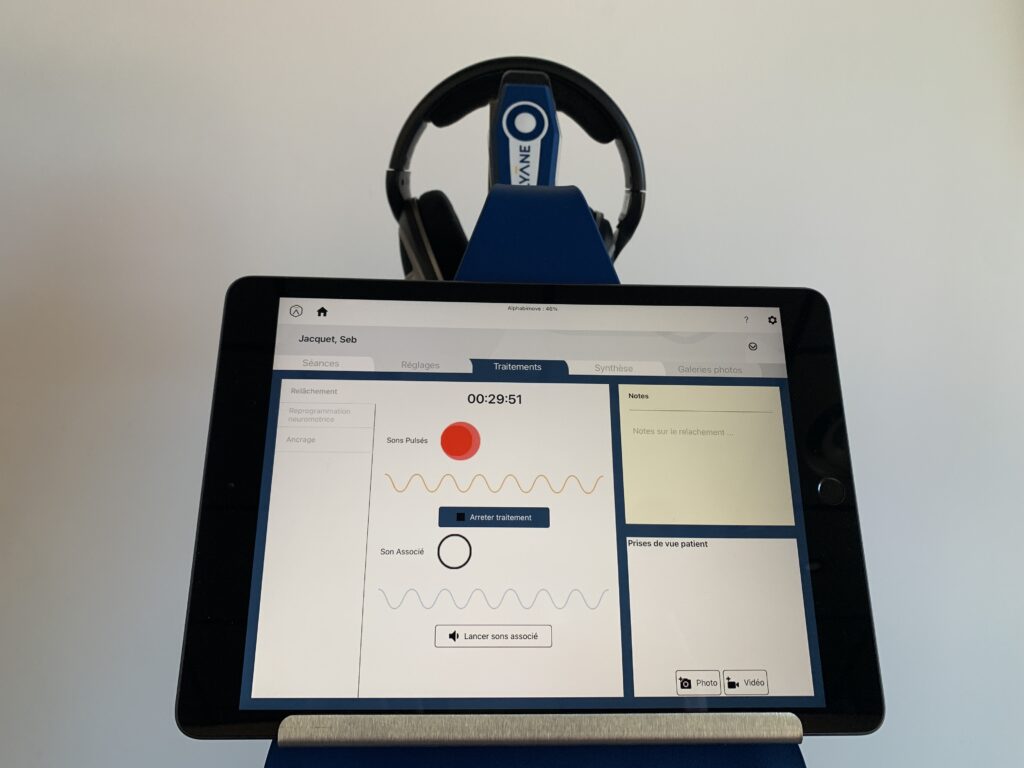 Tablette Alphabimove affichant l'interface du logiciel avec des écouteurs.