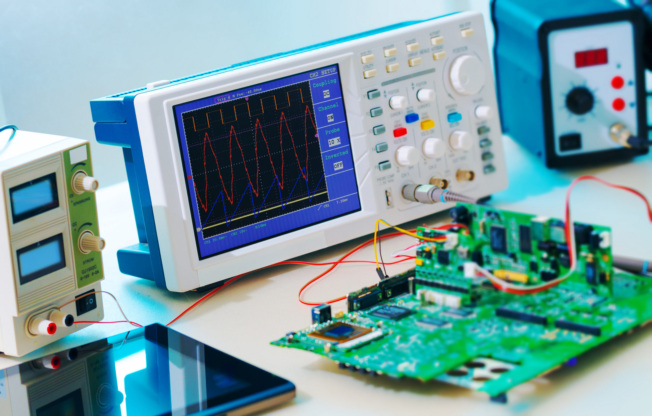 Oscilloscope affichant des ondes, circuit imprimé et équipement électronique. Tests et validation de prototypes.