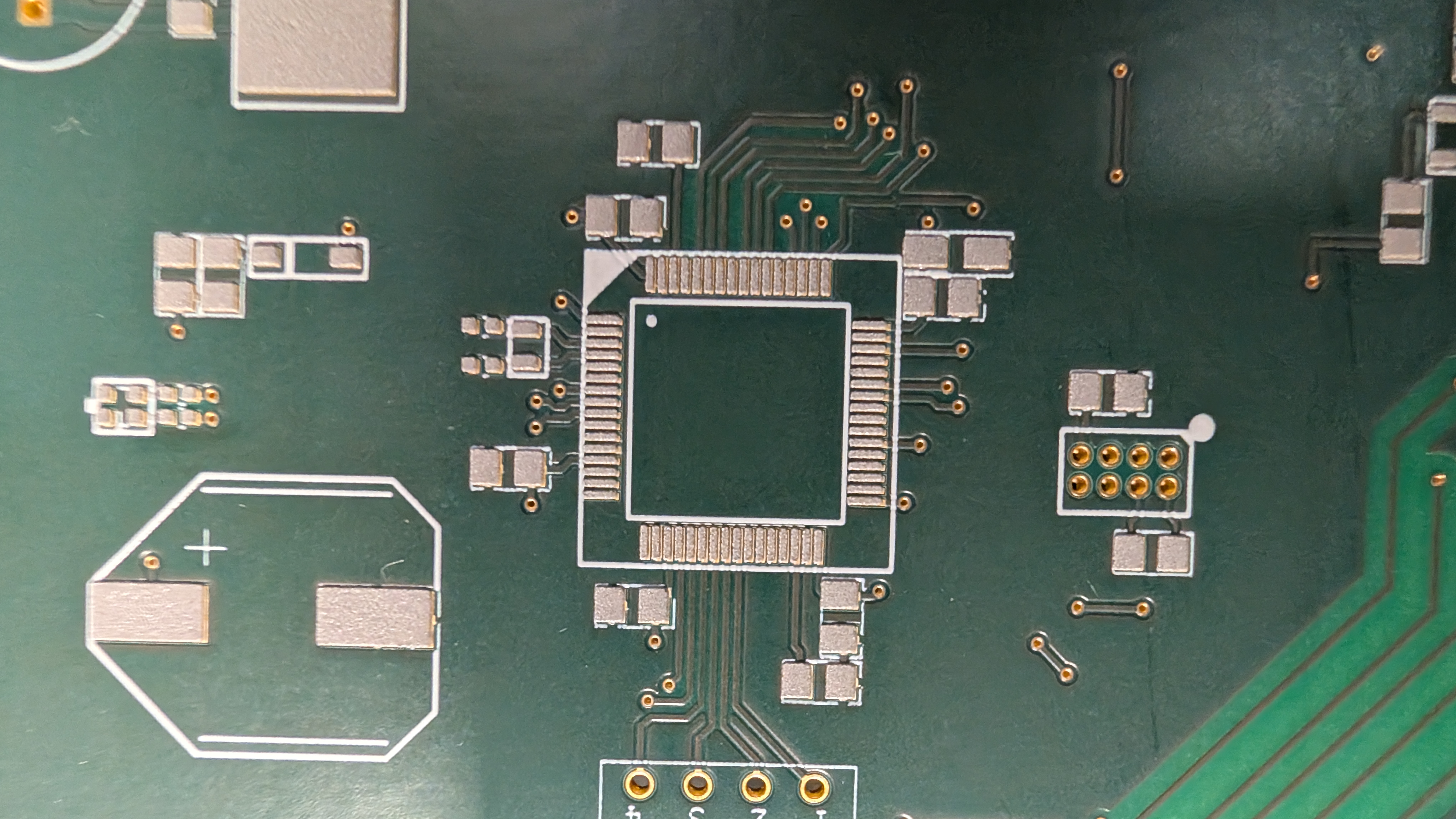 Prototype de carte électronique avec une puce centrale et des composants montés en surface.