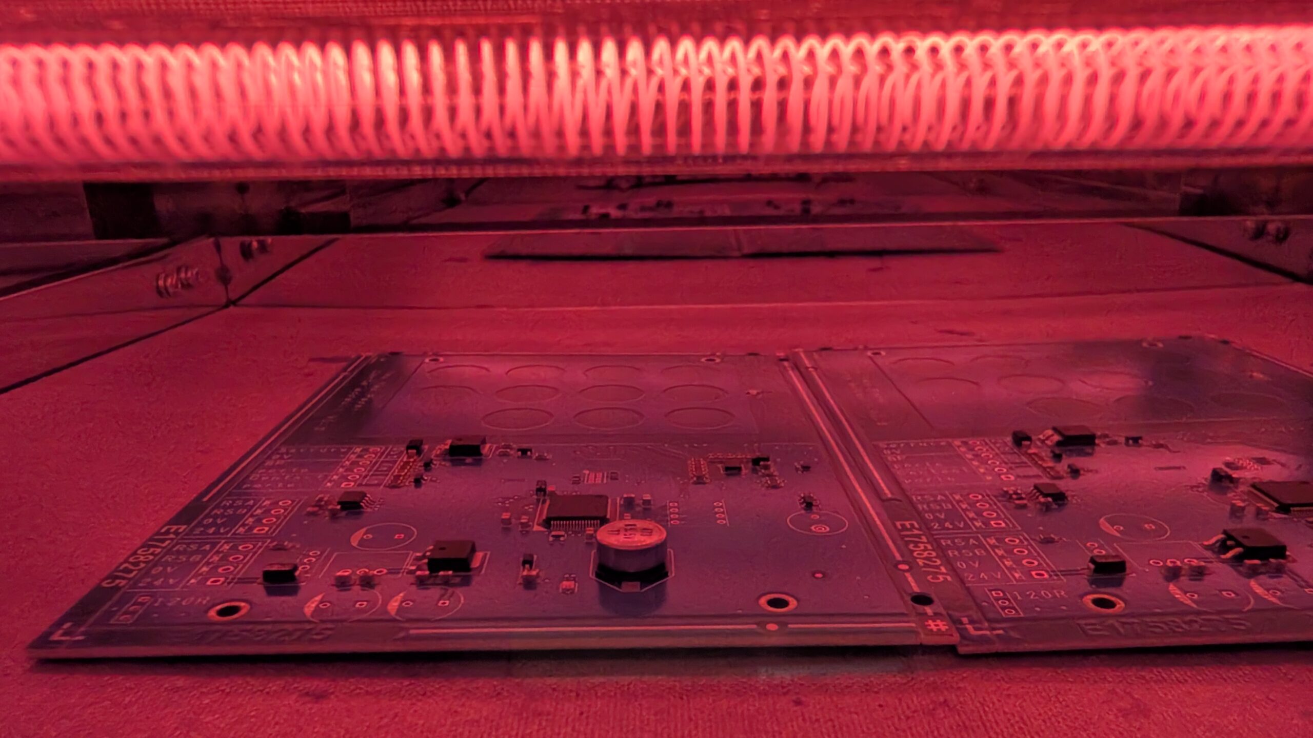 Prototypes de cartes électroniques sous lumière rouge, composants électroniques visibles. E1758275.